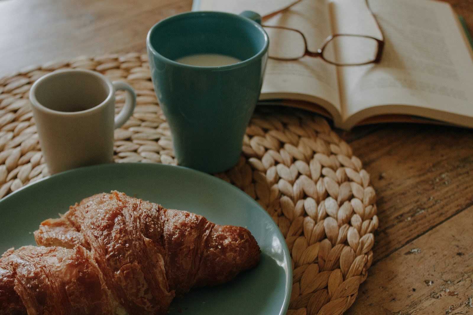 Photo by Rhamely a blue plate topped with croissants next to a cup of coffee